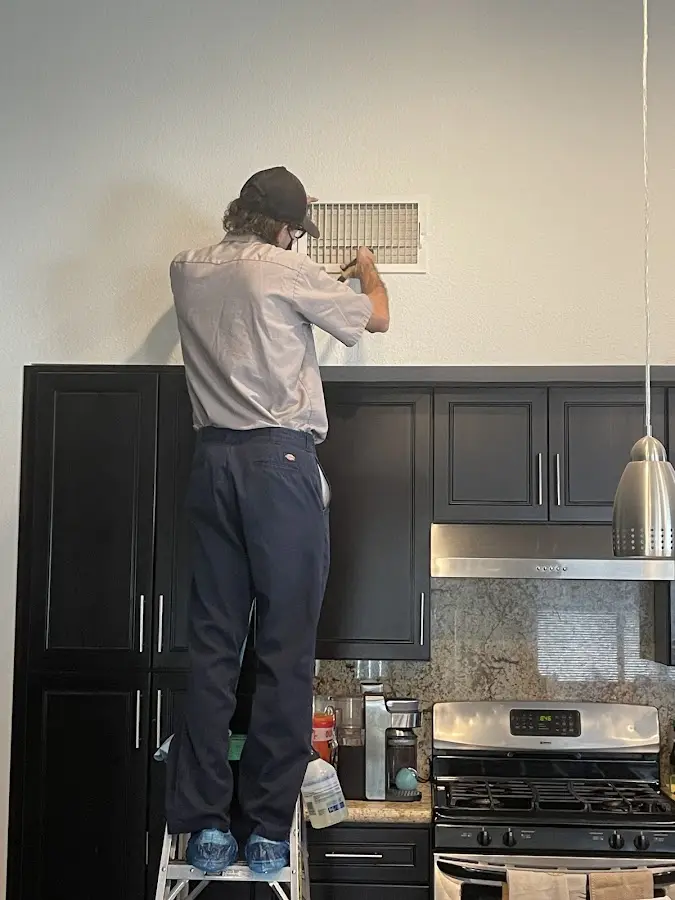 Technician inspecting an air vent during HVAC service in Coal City